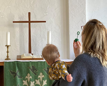 Frau mit Baby vor einem Altar
